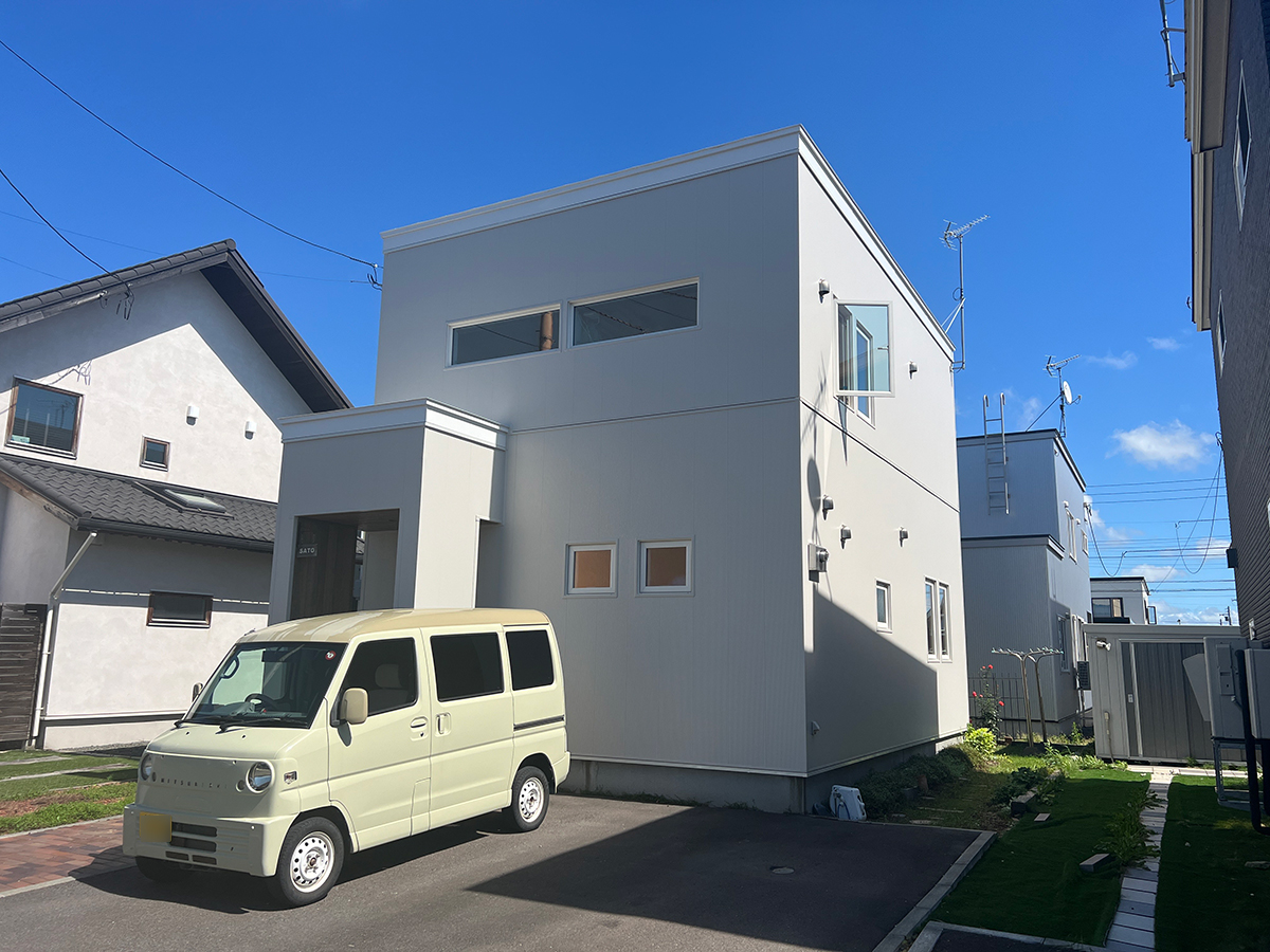 クールなホワイトキューブに木目のアプローチ